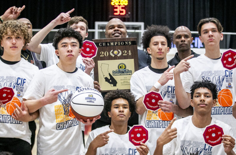 Castaic+head+coach+Dominique+Butler%2C+center%2C+holds+up+the+plaque+with+the+team+as+they+celebrate+winning+the+CIF+Southern+Section+Championship+on+Friday%2C+Feb.+23.+at+Azusa+Pacific+University.+Habdeba+Mostafa%2F+The+Signal