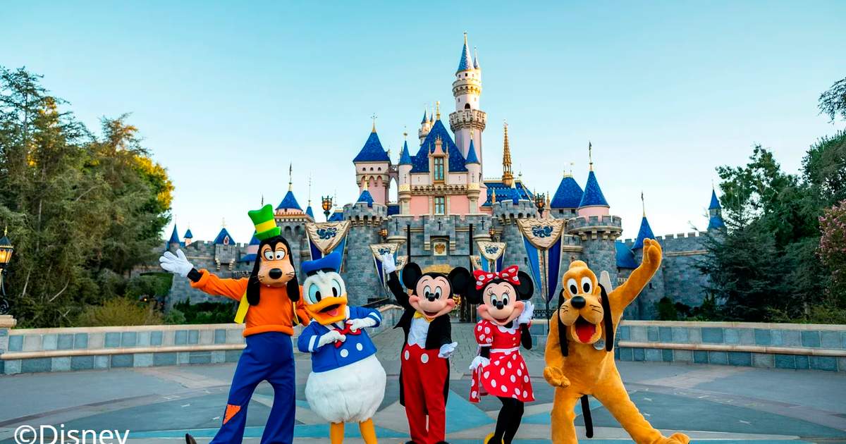 Iconic Disney characters standing in front of Sleeping Beauty's Castle.