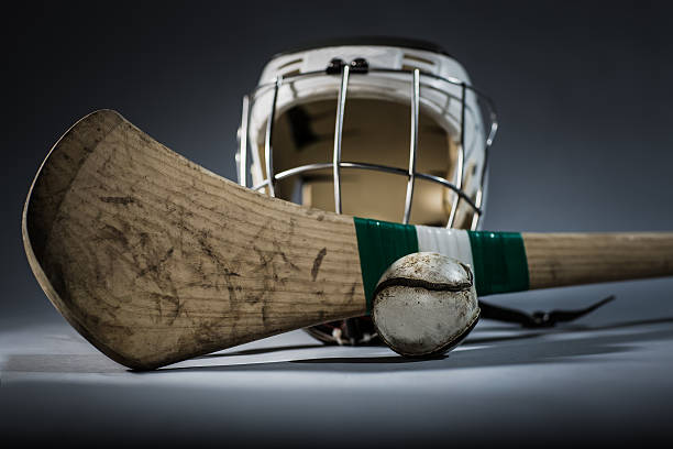 a studio shot of a hurling stick, ball, and helmet.