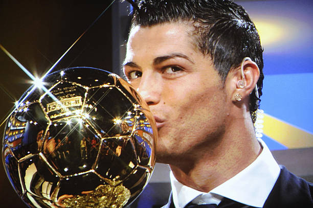 A photo taken on a TV screen shows Cristiano Ronaldo kissing his trophy  after he won the European footballer of the year award, the "Ballon d'Or" (Golden ball), on December 7, 2008 in Boulogne-Billancourt, outside Paris.AFP PHOTO FRANCK FIFE (Photo credit should read FRANCK FIFE/AFP via Getty Images)